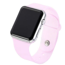 Smartwatch with silver case and light pink silicone strap, digital screen off, side button visible.
